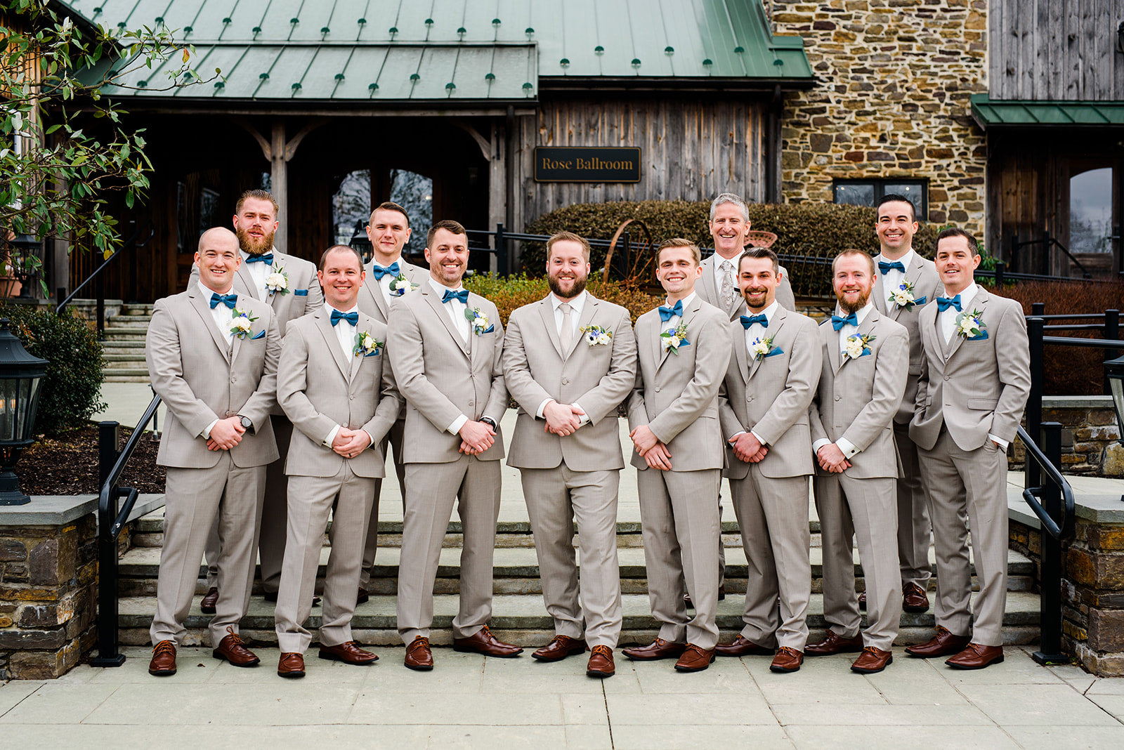 Group of men in gray suits standing on steps outdoors with a building in the background