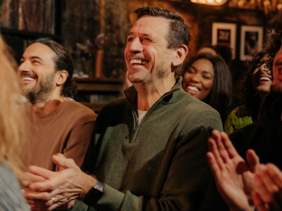 Group of people clapping and smiling in a social setting